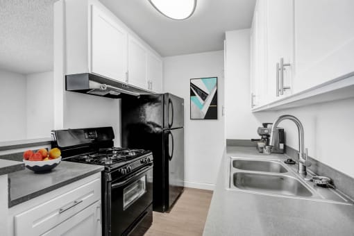 a kitchen with stainless steel counter tops and black appliances