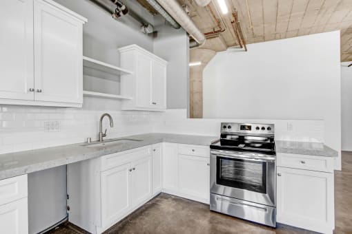 a kitchen with white cabinets and stainless steel appliances