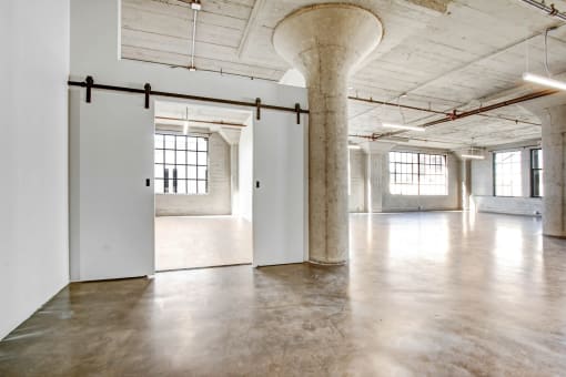 an empty room with white walls and concrete floors