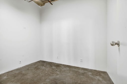 a white room with a concrete floor and white walls