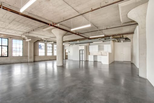 an empty warehouse space with concrete floors and white walls