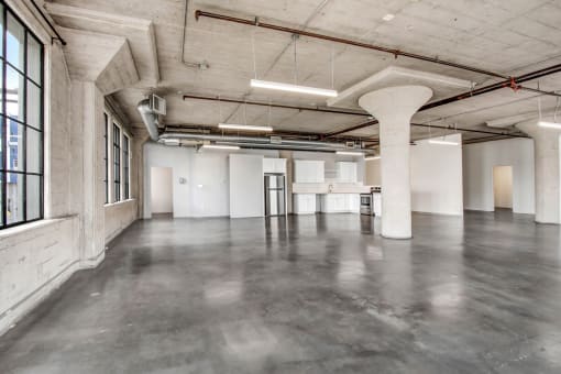 an empty warehouse space with concrete floors and white walls