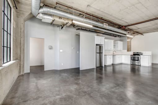 an empty room with white walls and concrete floors