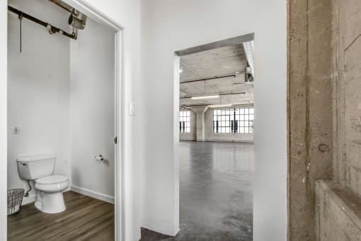 a bathroom with a white toilet and a wooden floor