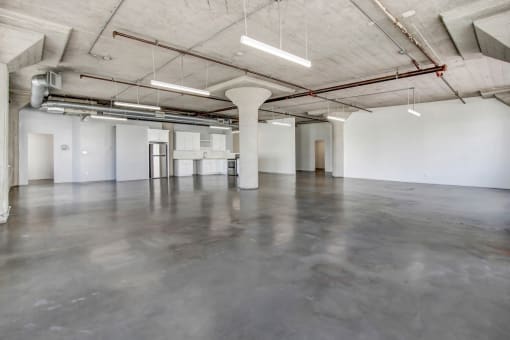 a large room with concrete floors and white walls