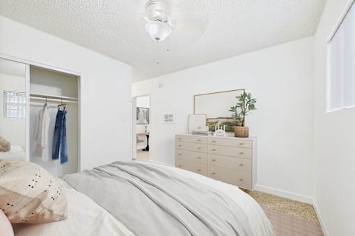 A bedroom with a bed, dresser, and mirror.