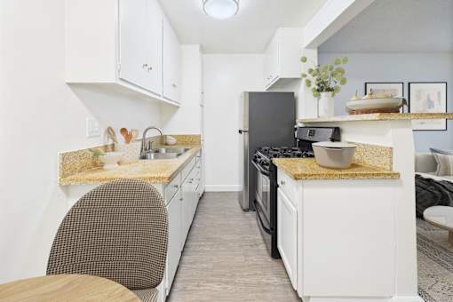 A kitchen with white cabinets and a granite countertop.