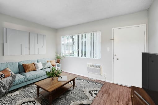 an open living room with a blue couch and a coffee table
