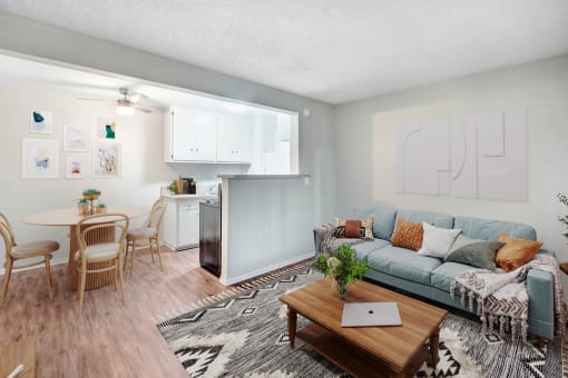 a living room with a couch and a table and a kitchen