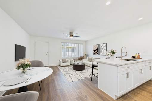 A modern kitchen and dining area with a white table and chairs.