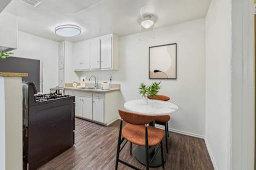 A kitchen with a table and chairs.