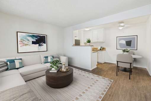 A living room with a white couch, a brown coffee table, and a painting on the wall.