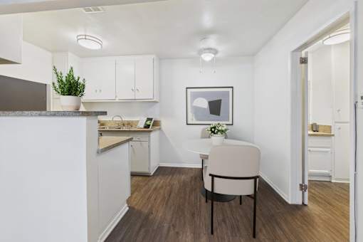 A kitchen with a table and chairs in the middle of the room.