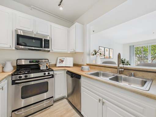 A kitchen with white cabinets and stainless steel appliances.