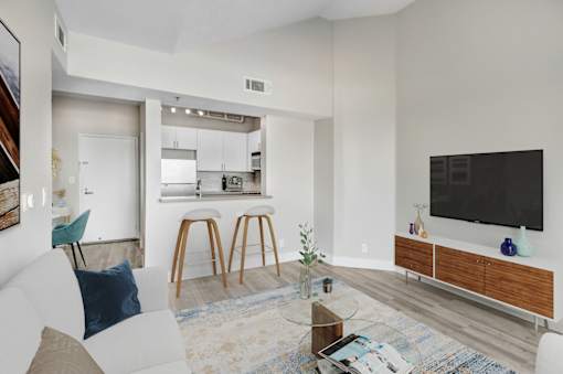 A modern living room with a white couch and a bar area.