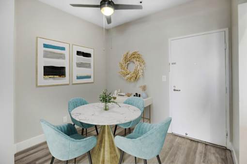 A dining room with a round table and blue chairs.