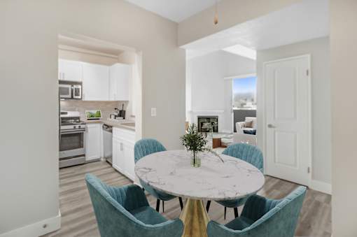 A kitchen with a table and chairs in the foreground.