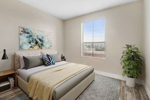 A bedroom with a large bed and a painting on the wall.