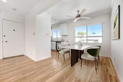 A room with a dining table and chairs.