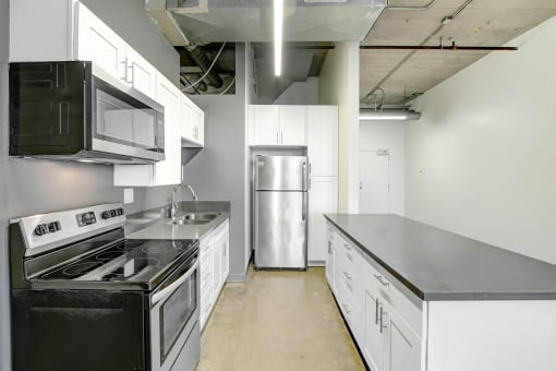 an empty kitchen with white cabinets and stainless steel appliances