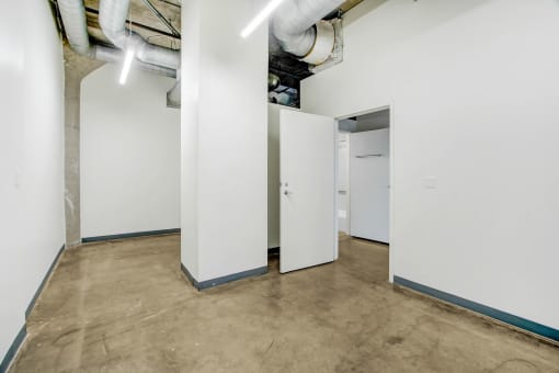 a room with white walls and doors and a cement floor