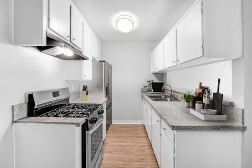 a renovated kitchen with white cabinets and stainless steel appliances