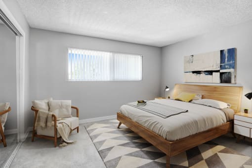 a bedroom with a bed and a chair and a window