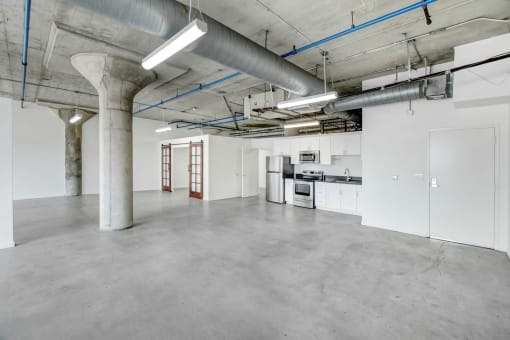 the interior of an empty warehouse with white walls and concrete floors