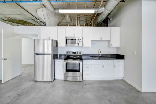 a kitchen with white cabinets and a stainless steel refrigerator