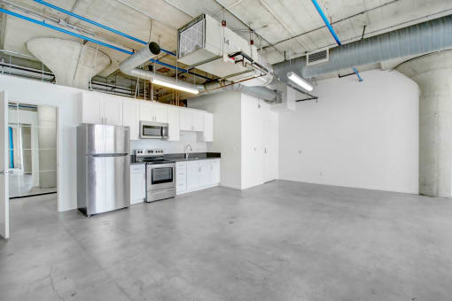 a kitchen with white cabinets and a stainless steel refrigerator
