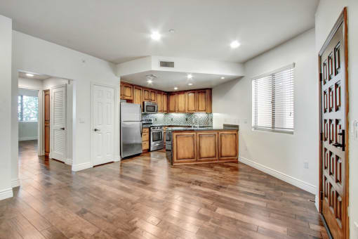 a kitchen and living room with hardwood floors and white walls