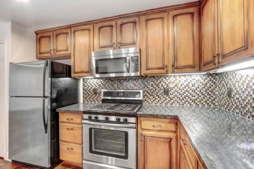 a kitchen with wooden cabinets and stainless steel appliances