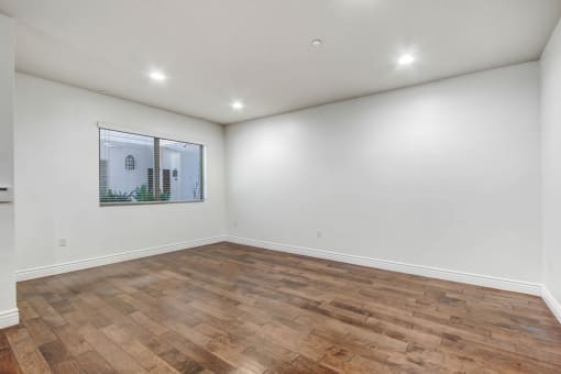 a room with a hardwood floor and white walls