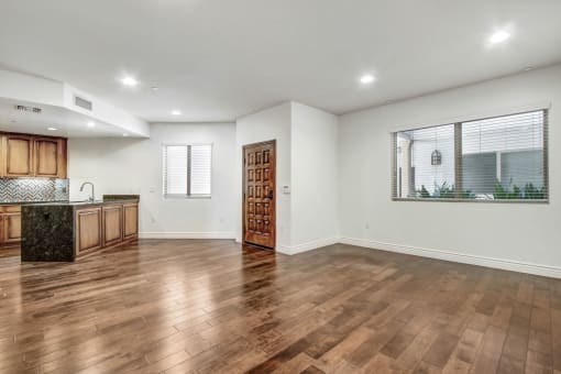 a kitchen and living room with hardwood floors and a large window