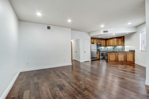a kitchen and living room with hardwood floors and white walls