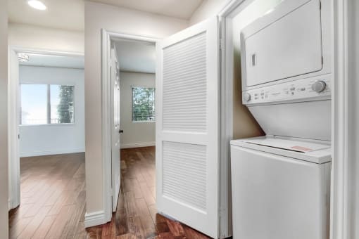 a washer and dryer in a room with a hardwood floor