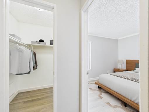 A white bedroom with a bed and a wardrobe.