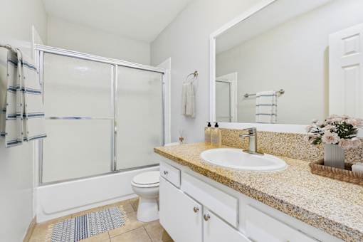 A bathroom with a sink, toilet, and shower.