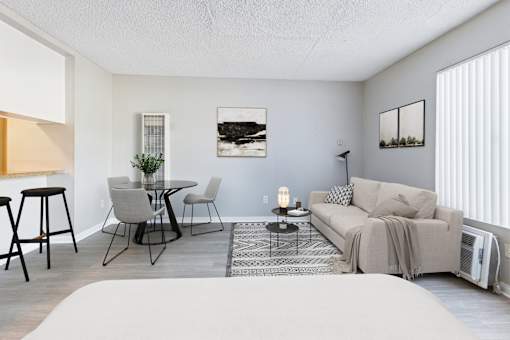 A living room with a grey couch, a coffee table, and a lamp.