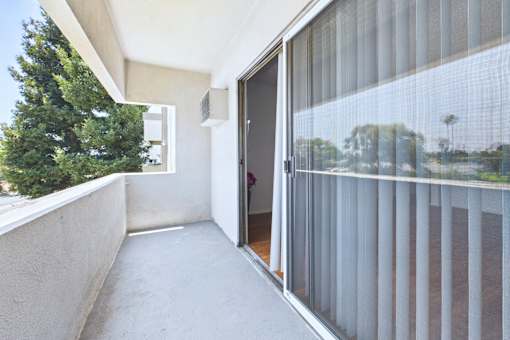 A balcony with a glass door and a glass window.