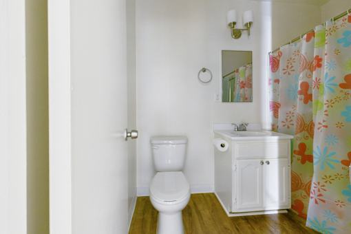 A white toilet sits next to a white sink in a small bathroom.