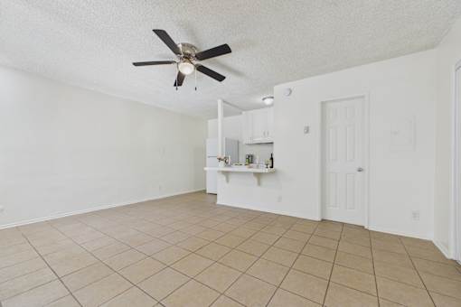 A room with a ceiling fan and tiled floor.