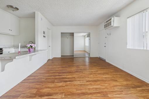 A kitchen with a wooden floor and white walls.