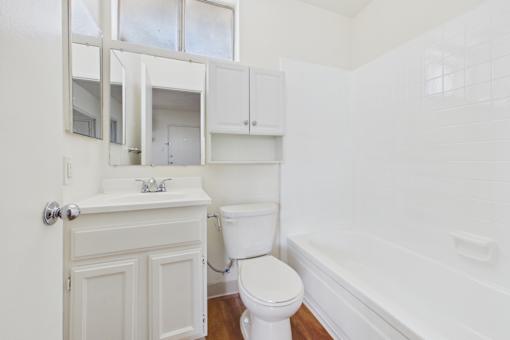 A white bathroom with a toilet, sink, and bathtub.