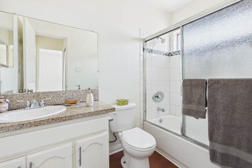 A white toilet sits next to a sink in a bathroom.