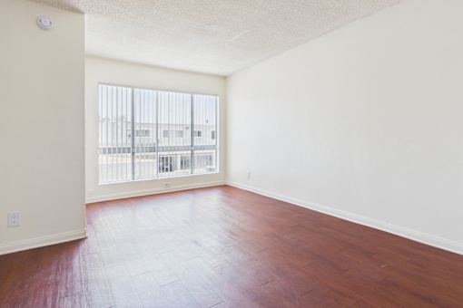 Empty room with wooden floor and white walls.