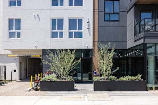 A modern building with a white and grey facade and a black door at Skylar At Sunset Apartments, Los Angeles, California