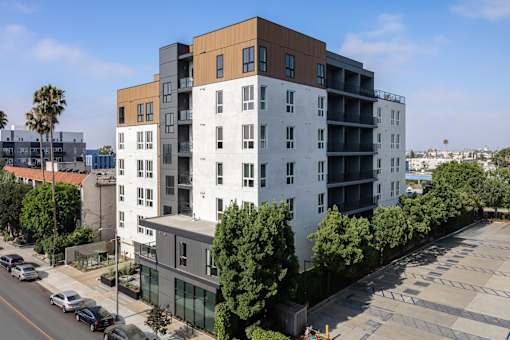 A modern multi-story building with a parking lot in front at Skylar At Sunset Apartments, California, 90027