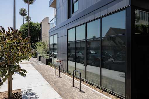A modern building with a tree in front of it at Skylar At Sunset Apartments, Los Angeles 90027