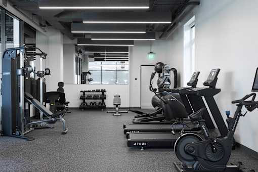 A gym with a variety of equipment including treadmills, weights, and exercise machines at Skylar At Sunset Apartments, California, 90027